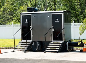 luxury portable toilet next to a white fence